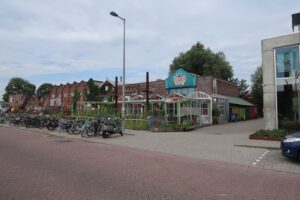 Straatbeeld van het Gedempt Hamerkanaal in Amsterdam met fietsenstalling, industriële panden en het cultureel centrum De Ceuvel.